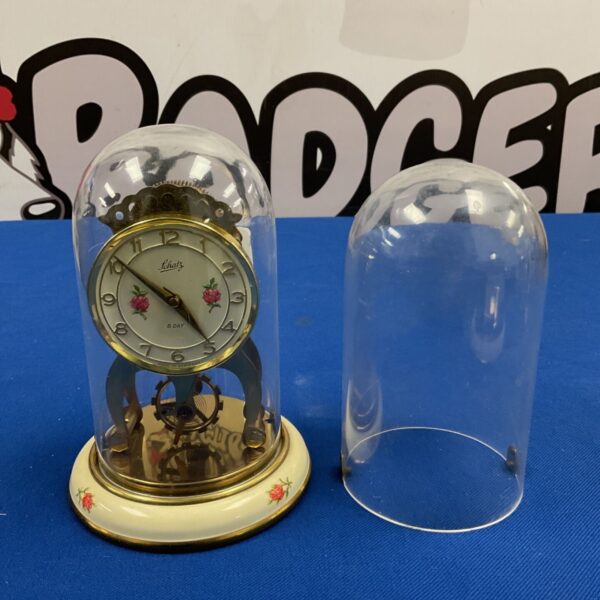 Schatz 8 day anniversary clock under glass dome beside spare dome
