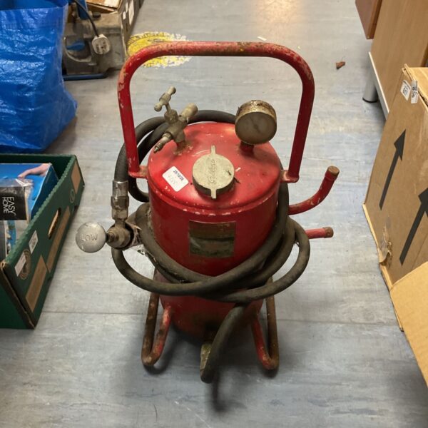 Red Sellarc pneumatic grease pressure pump with coiled hose and pressure gauge