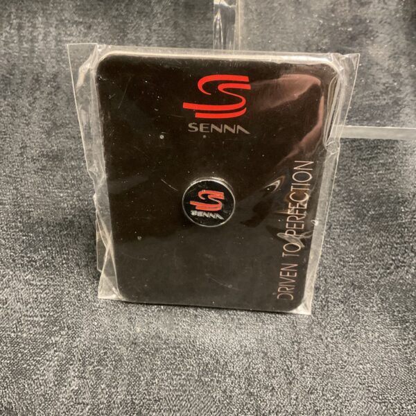 Ayrton Senna pin badge in original packaging, front view.
