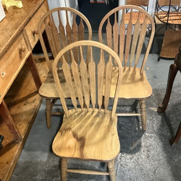 Set of three wooden dining chairs with arched spindle backs and turned legs