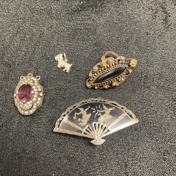 Vintage Siam silver brooch lot with intricate designs.