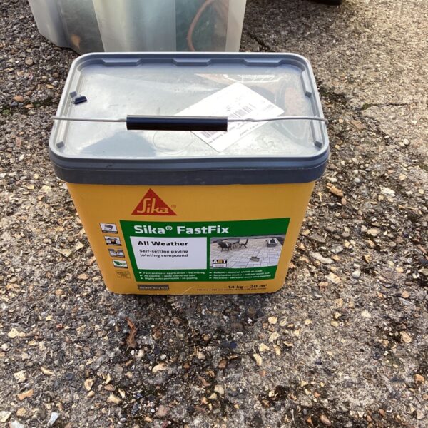 Grey tub of Sika Fastfix jointing compound for garden paving.