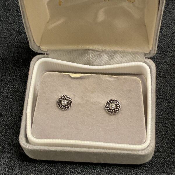 Silver Celtic knot stud earrings with a white stone setting.
