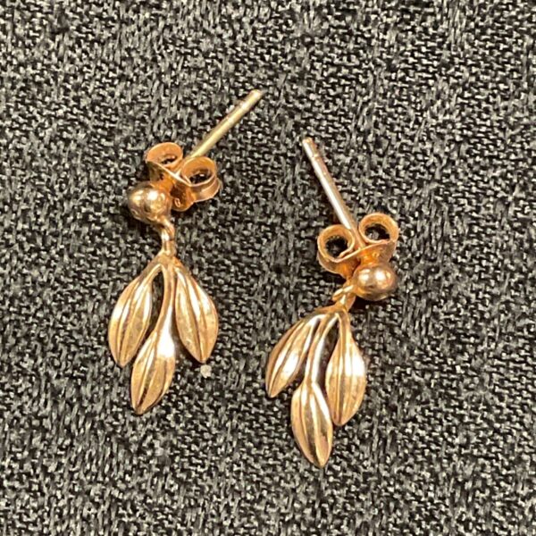Close-up of delicate silver gilt floral stud earrings.