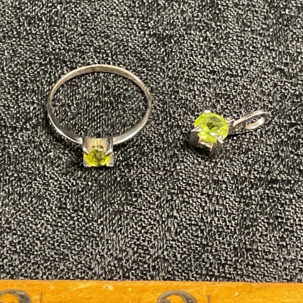 Silver ring and pendant set with a vibrant green peridot gemstone.