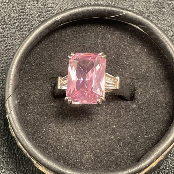 Silver ring with a pink cubic zirconia and baguette accents.