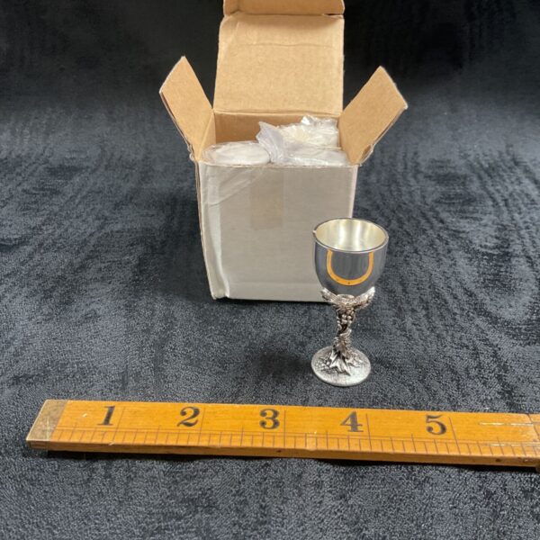 Silver plate goblet place card holder on cardboard box.