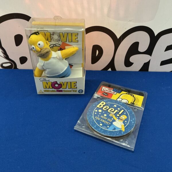 The Simpsons Movie DVD with Homer Simpson toy and coasters.