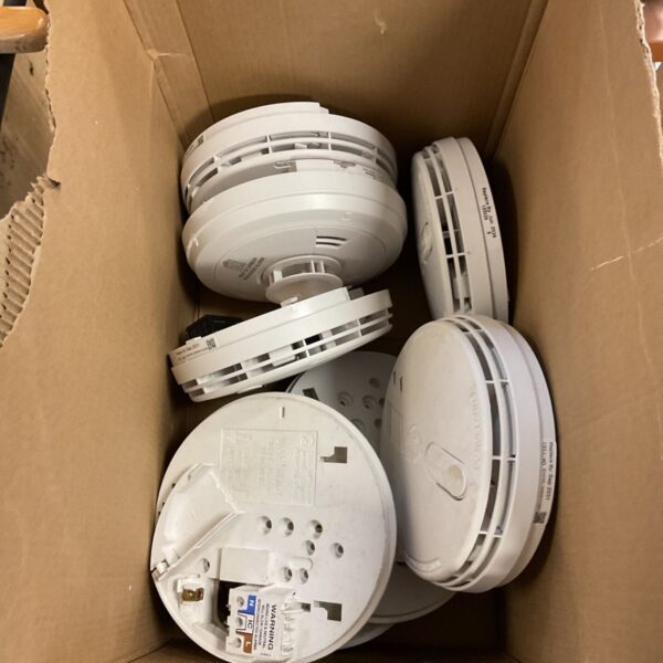 Box of white smoke and carbon monoxide detectors with mains wiring bases