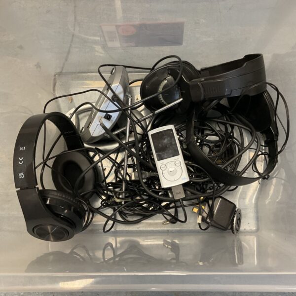 Box of mixed headphones and silver Sony MP3 player with loose cables
