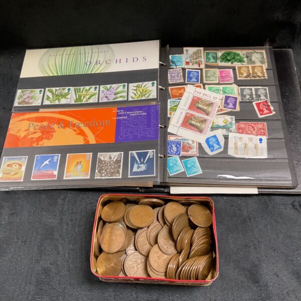 Royal Mail Mint Stamps Orchids and Peace and Freedom packs beside stamp album and penny tin