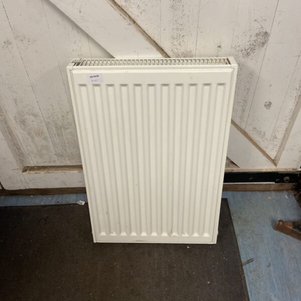 White steel central heating panel radiator with vertical flutes and top fins