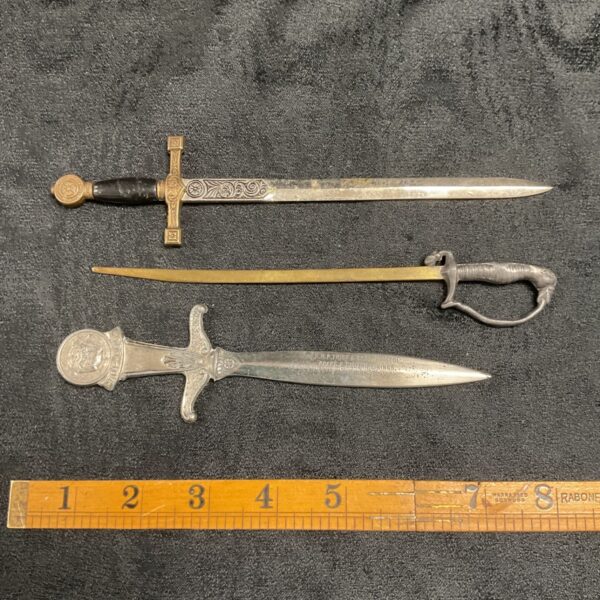 Antique sword letter opener set, detailed brass handle, Victorian style.