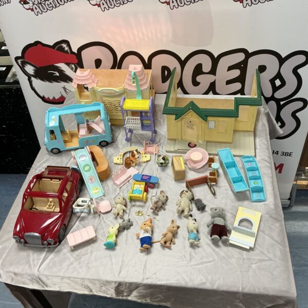 Sylvanian Families houses, figures and red car collection laid out on table