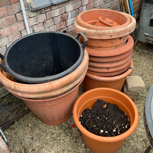 Stack of terracotta garden planters for outdoor use.