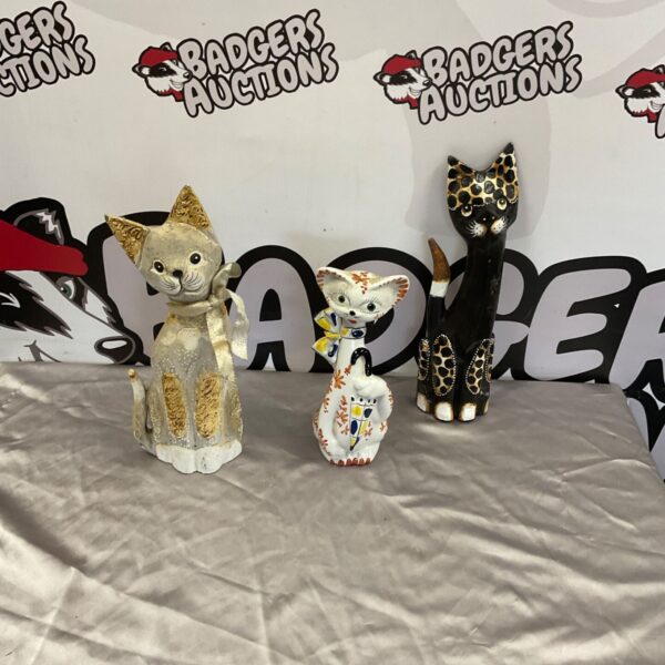 Three decorative cat ornaments in gold, white and black finishes