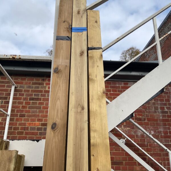 Three bundles of 10'6" softwood timber leaning against a wall