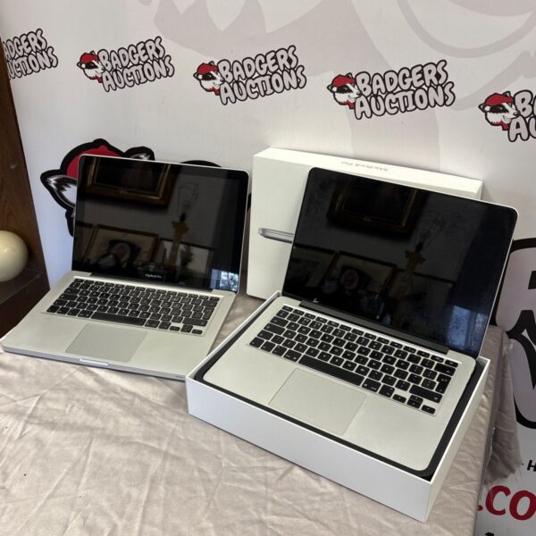 Two silver Apple MacBook Pro laptops for repair, one boxed