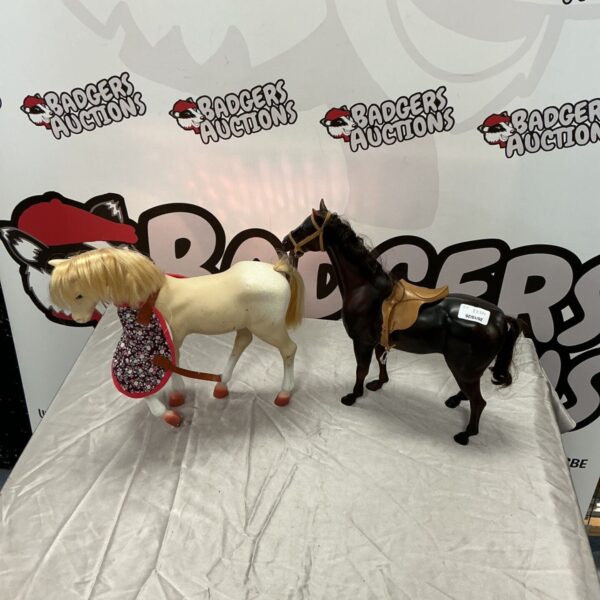 Two plastic toy horses, one cream with blonde mane, one brown with tan saddle