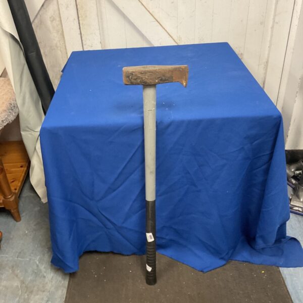 Tyre bead breaker hammer with rusted rectangular head and grey shaft