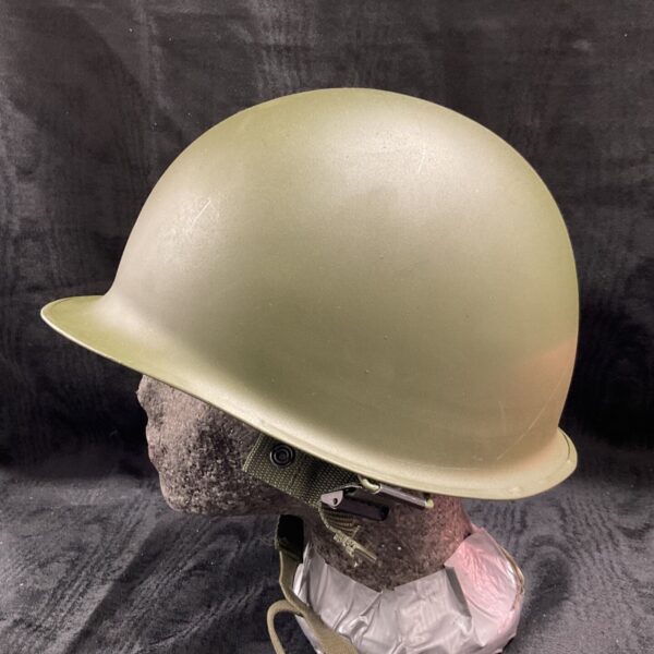 Vintage US Military helmet with khaki finish and chinstrap.