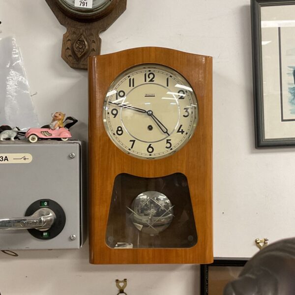 Vintage Valmet wall clock with pendulum, a classic mid-century timepiece.