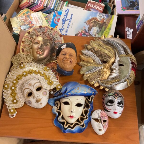 Assorted Venetian wall masks and a sailor wall hanging figure on wooden table