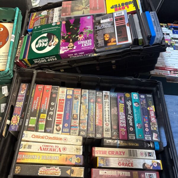Assorted VHS tapes and DVDs in a mixed media lot.