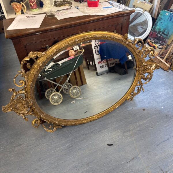 Large antique Victorian bevelled glass mirror with ornate gilt frame.