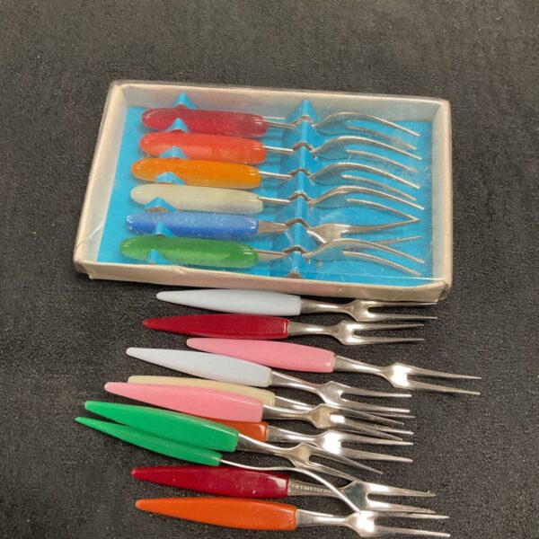 Vintage 1950s cocktail forks with colourful plastic handles.