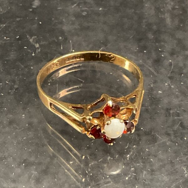 Close-up of vintage 9ct gold ring with opal and ruby stones.