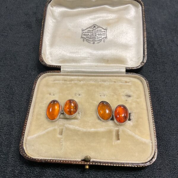 Vintage silver cufflinks with amber stones in a leather box.
