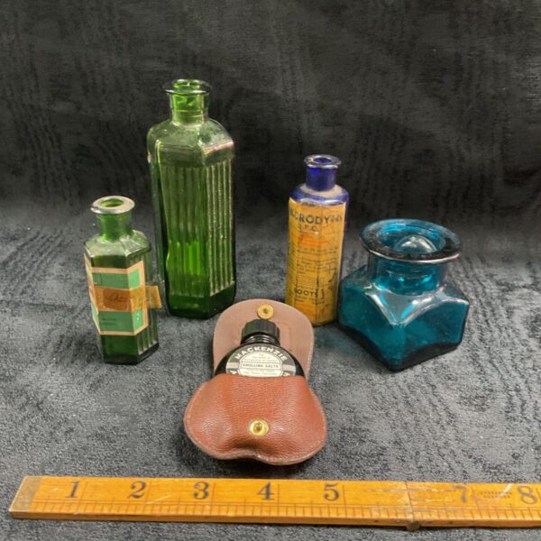 Five vintage apothecary bottles with Mackenzie smelling salts in leather pouch
