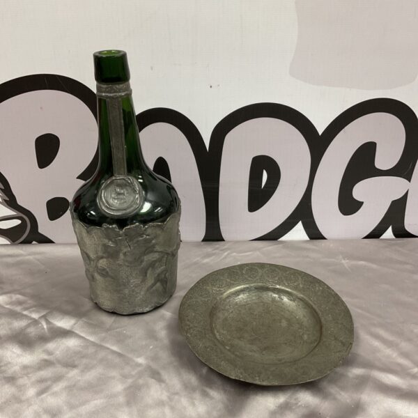 Vintage Art Nouveau pewter covered glass bottle beside silver plate dish
