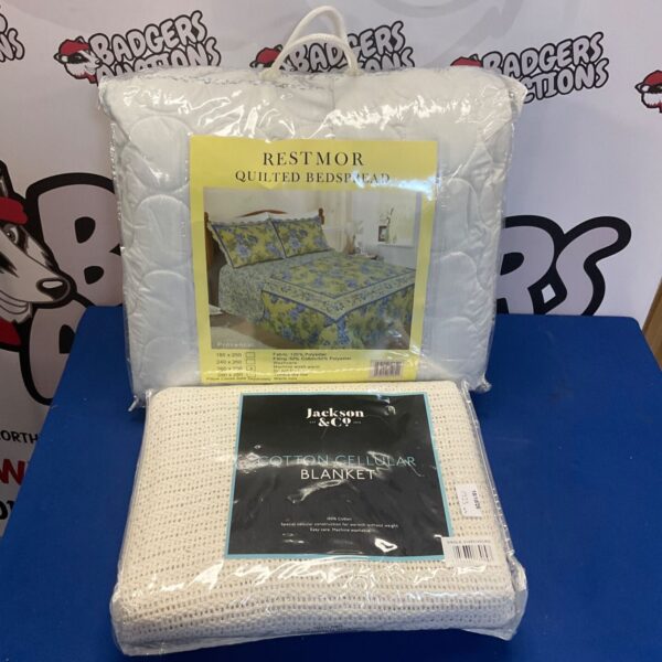 Vintage quilted bedspread and cotton cellular sheet displayed.