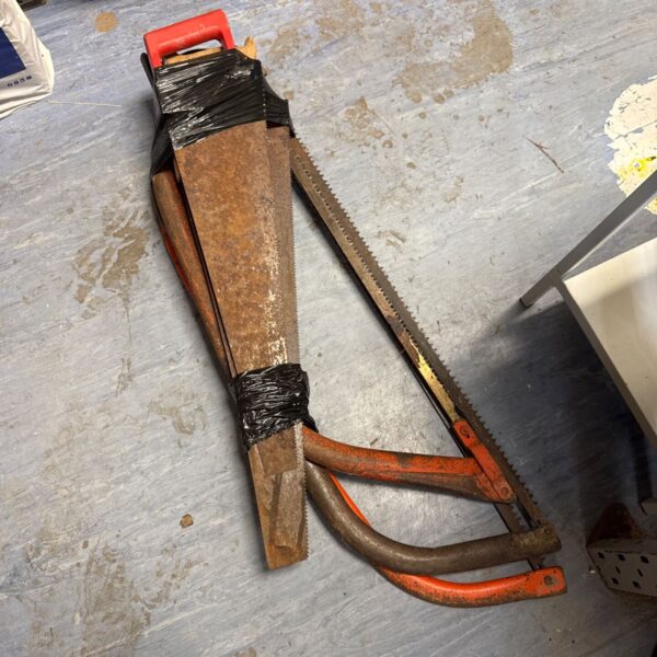 Vintage bow saw with a curved metal frame and blade.