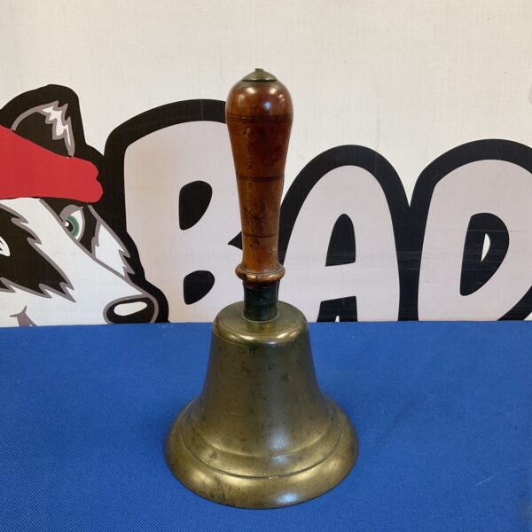 Vintage brass hand bell with wooden handle, a collectible antique.