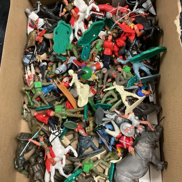 Cardboard box filled with vintage plastic toy soldiers, horsemen and Roman figures