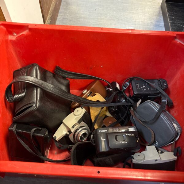 Vintage Canon and Kodak cameras in a lot with cases.