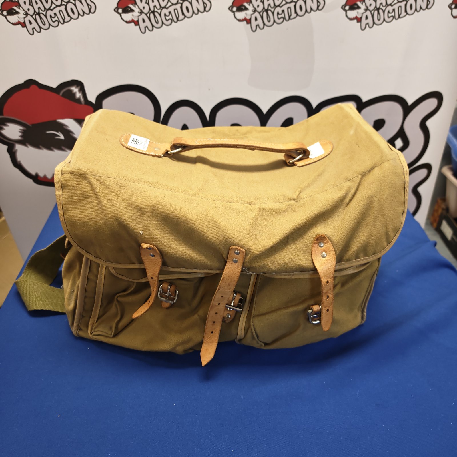 Vintage canvas shoulder bag with leather straps and buckles.