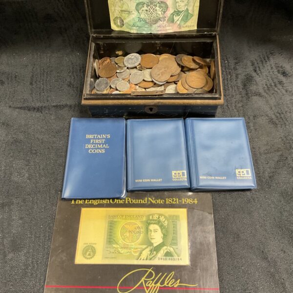 Vintage black cash tin with mixed coins, banknotes and coin wallets