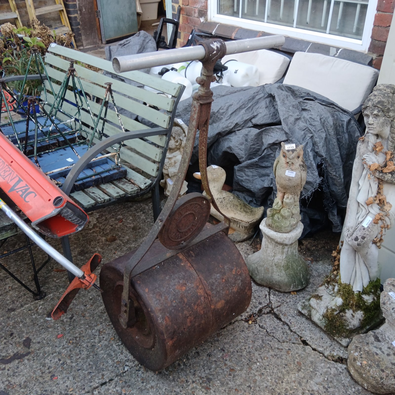 Large vintage cast iron garden roller with rusted drum and metal crossbar handle