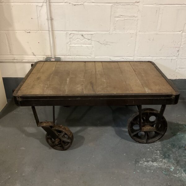 Vintage cast iron station trolley coffee table with timber top and iron wheels