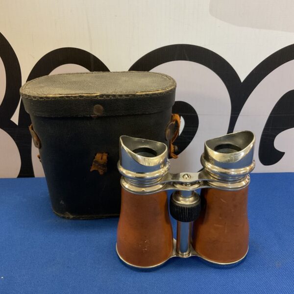 Vintage chrome binoculars with a worn leather case.
