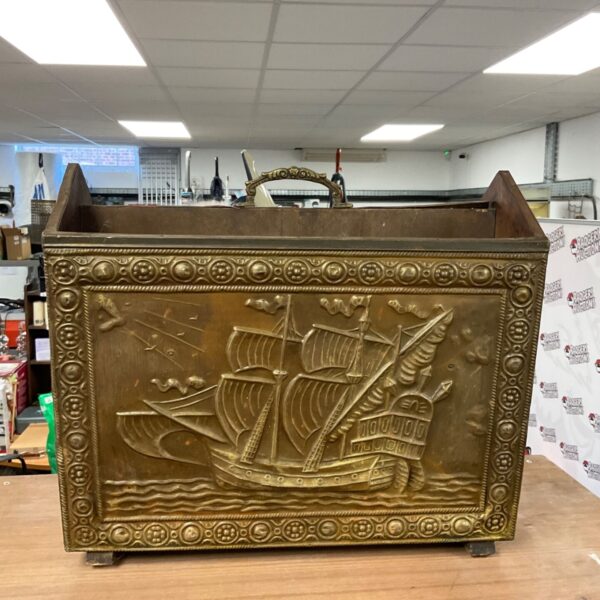 Vintage copper magazine rack with a detailed ship design.