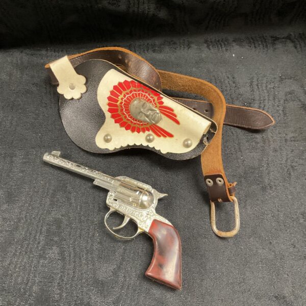Vintage Crescent Dakota cap gun beside black leather-effect cowboy holster