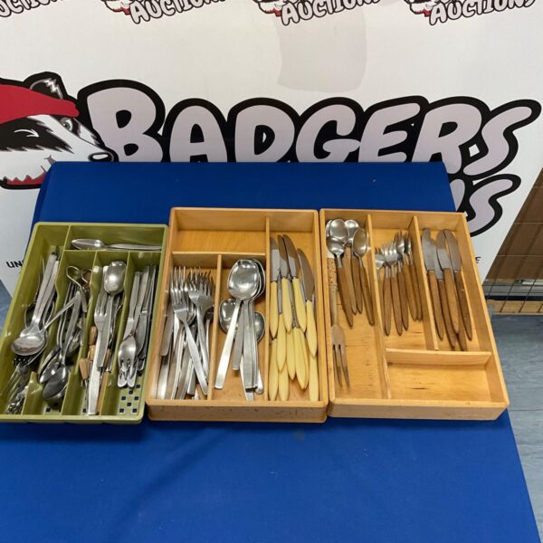 Vintage cutlery set displayed in three trays, a mixed collection.
