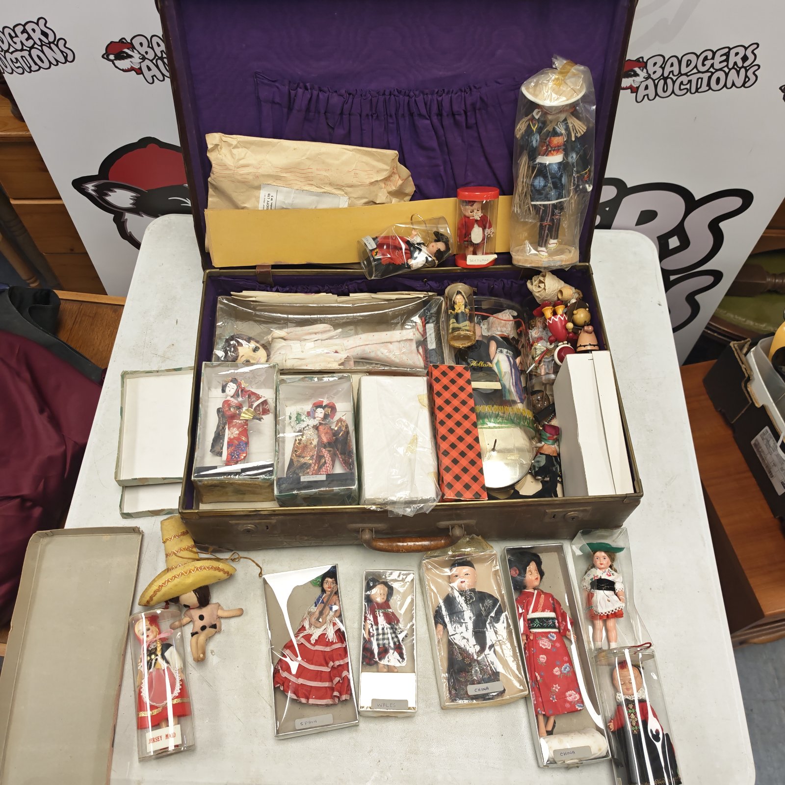 Vintage dolls from around the world displayed in an open alligator style suitcase