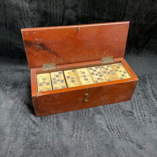 Vintage dominoes in wood box with open lid and brass hinges