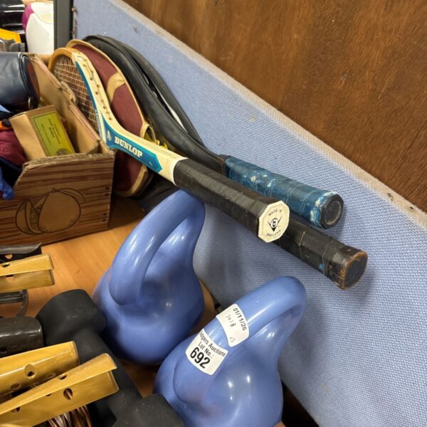 Vintage Dunlop tennis rackets and blue kettlebells displayed together in an auction lot